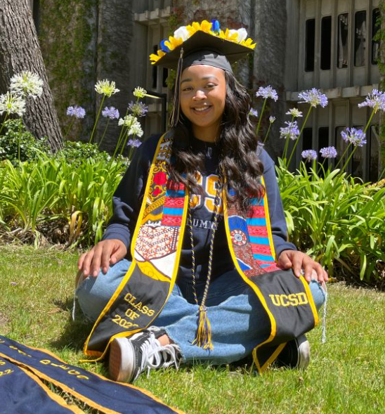 New graduate sitting on lawn.
